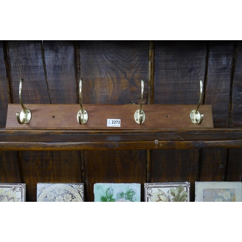 2270 - A 2' coat rack with four double brass hooks