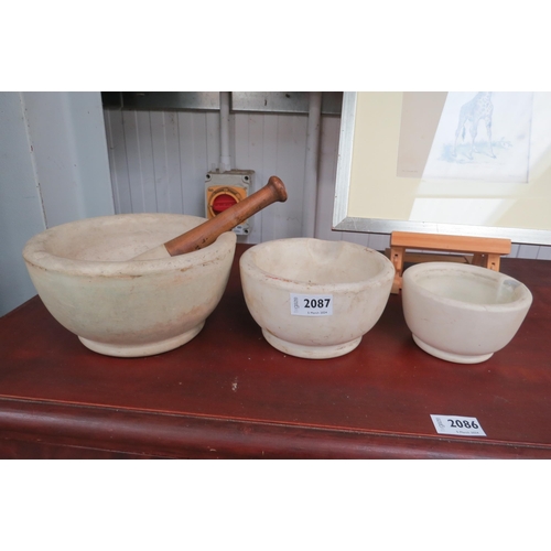 2087 - A graduated set of three pestles and one mortar, stamped verso