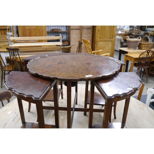 2244 - A 1930's walnut circular wavy edged coffee table with nest of four triangular tables