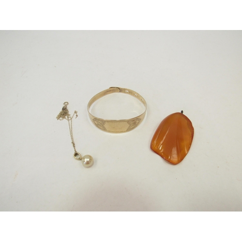 1312 - A 9ct gold cuff bangle, a pearl pendant stamped 18k on fine gold chain and an amber pendant