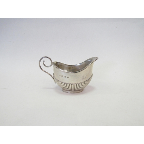 1324 - A Victorian silver cream jug, fluted detail, scrolled handle, London 1897