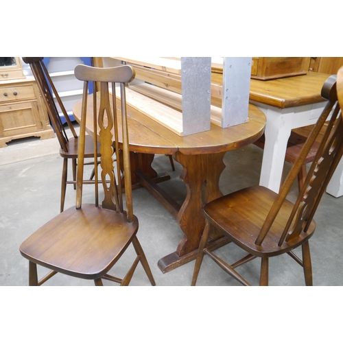 2264 - A drop flap kitchen table shaped supports and four kitchen chairs