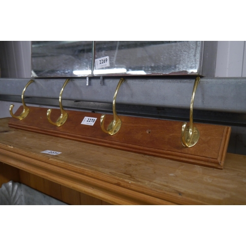 2270 - A 2' coat rack with four double brass hooks