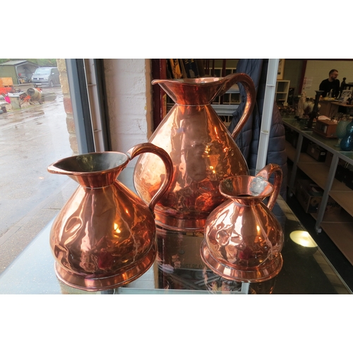 1232 - Three 19th Century graduating copper measure jugs