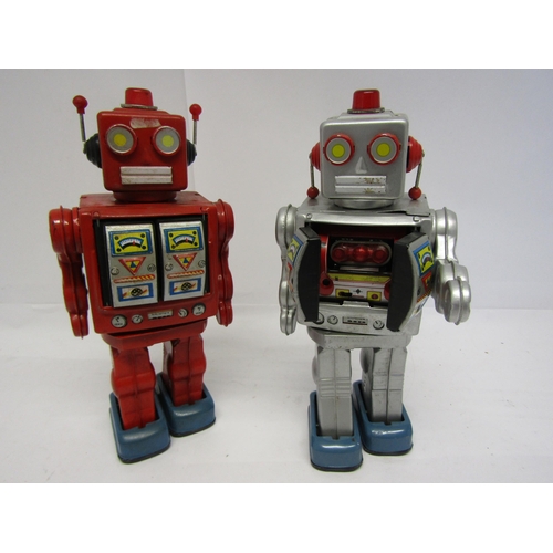 8071 - A Japanese red tinplate battery operated robot with chest doors opening to reveal plastic guns, toge... 