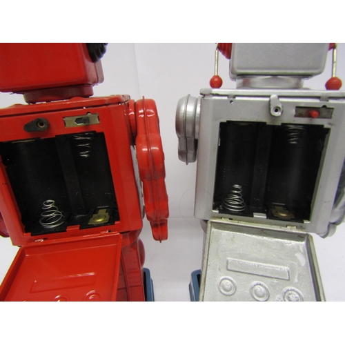 8071 - A Japanese red tinplate battery operated robot with chest doors opening to reveal plastic guns, toge... 