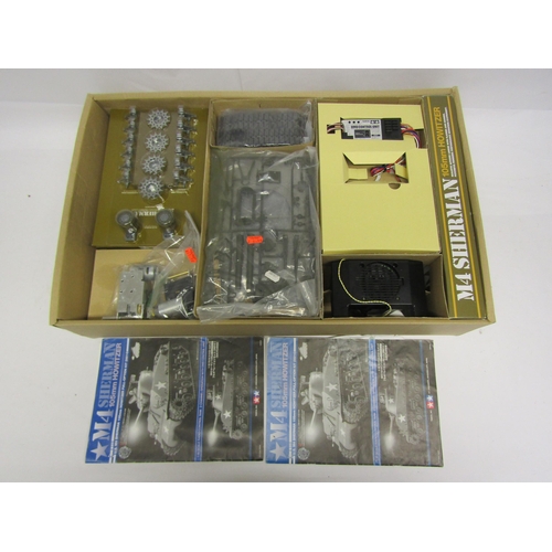 8411 - A boxed Tamiya 1/16 scale radio control M4 Sherman 105mm Howitzer model tank kit with 2-channel oper... 