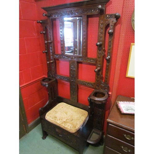 4096 - A late Victorian carved oak hall/stick stand with twelve turned hanging pegs, the box seat settle wi... 