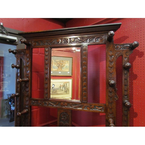 4096 - A late Victorian carved oak hall/stick stand with twelve turned hanging pegs, the box seat settle wi... 