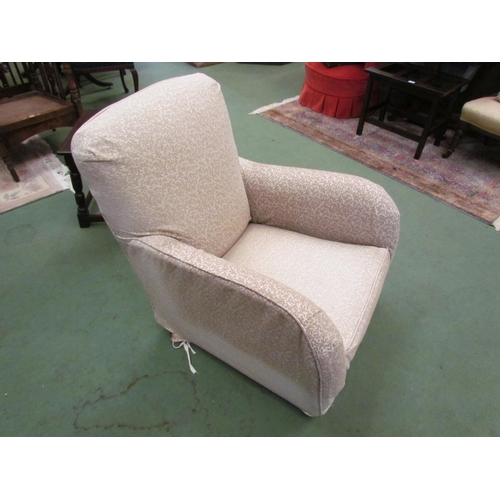 4110 - A Circa 1920 rounded armchair on castors with removable loose cover    (R) £60