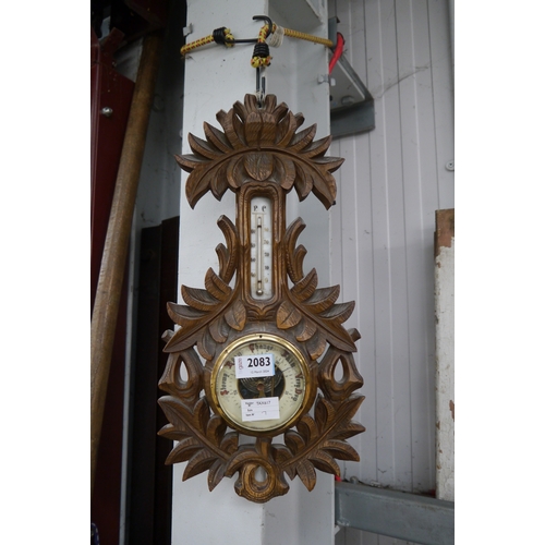 2083 - An early 20th Century carved oak wall barometer with all-over leaf design