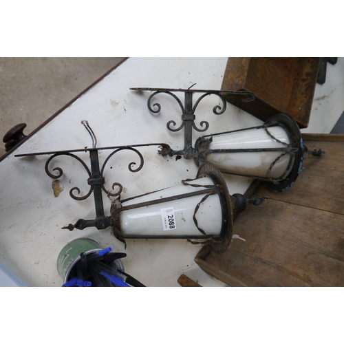 2088 - A pair of wrought iron outside lights with glass shades