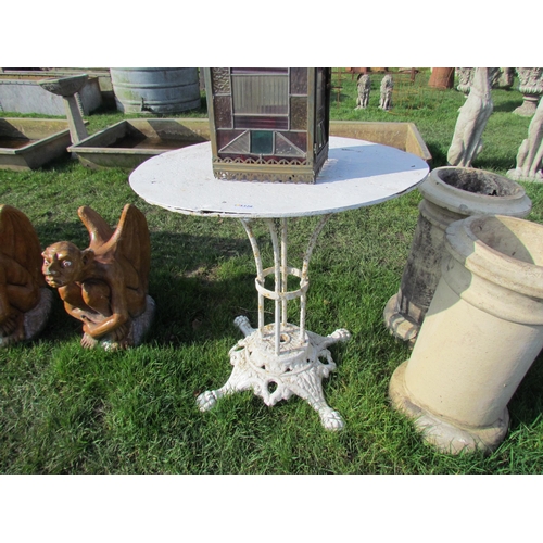 5328 - A cast iron based, circular metal topped garden table, 29