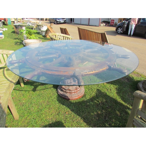 5450 - A large ships wheel garden table with glass top on a shaped glazed stoneware base  (R)  £350