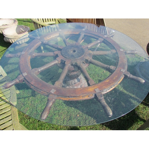 5450 - A large ships wheel garden table with glass top on a shaped glazed stoneware base  (R)  £350