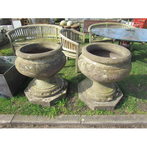 5475 - A pair of large weathered stone urns on octagonal bases, foot on one damaged, 31