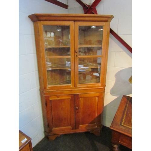 1079 - A Victorian pitch pine corner cupboard, the glazed doors opening to reveal shelved interior over two... 