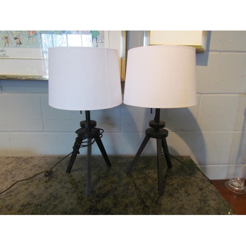 1085 - A pair of modern lacquered table lamps on tripod feet with white shades