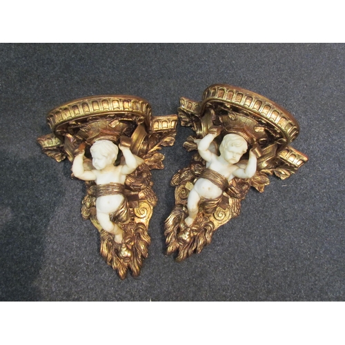 1110 - A pair of gilt and resin cherub wall brackets