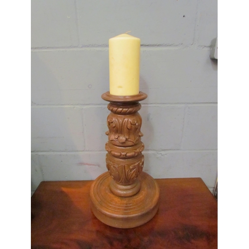 1121 - A large ornately carved candle holder with candle