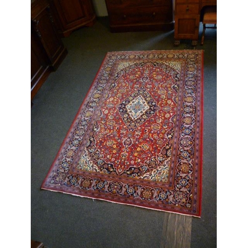 1561 - An Iranian red ground rug with floral design, multiple borders, 225cm x 142cm