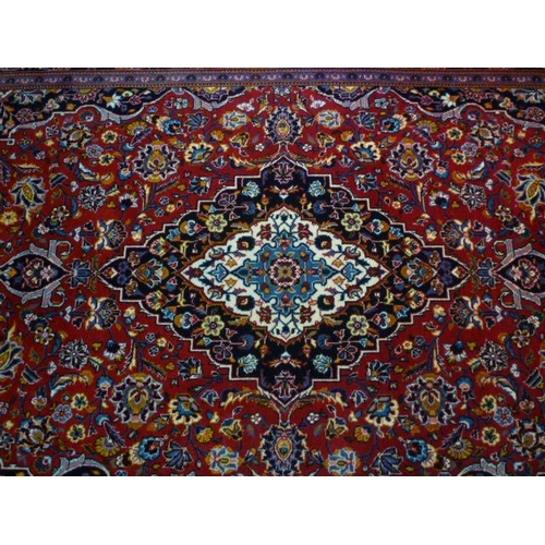 1561 - An Iranian red ground rug with floral design, multiple borders, 225cm x 142cm