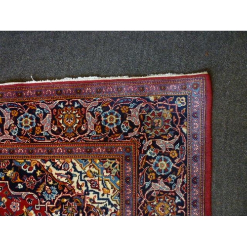 1561 - An Iranian red ground rug with floral design, multiple borders, 225cm x 142cm