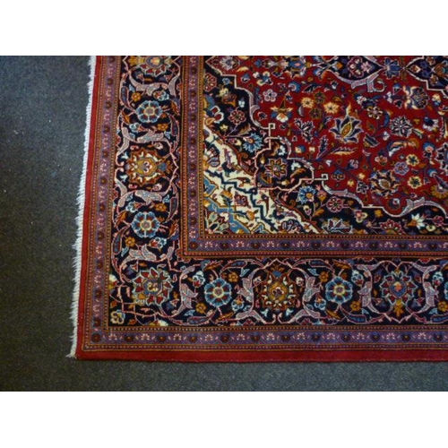 1561 - An Iranian red ground rug with floral design, multiple borders, 225cm x 142cm