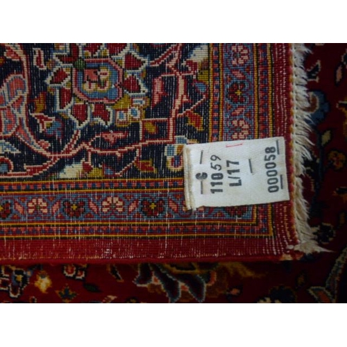 1561 - An Iranian red ground rug with floral design, multiple borders, 225cm x 142cm