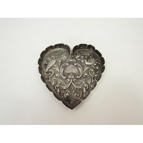 1306 - A William Comyns silver heart shaped pin dish with embossed floral, bird and mask design.  London 18... 