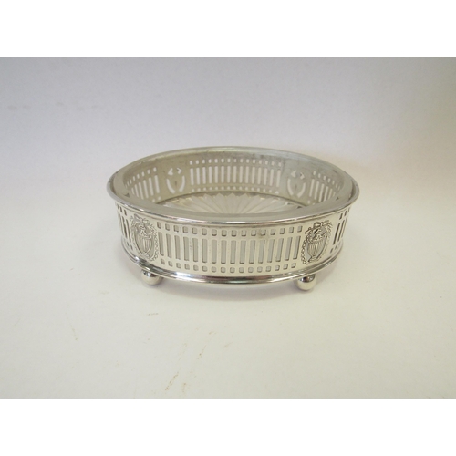 1315 - A pierced silver glass lined butter dish of oval form with engraved floral and urn design on four ba... 