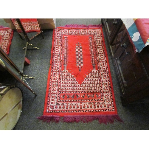 1102 - A Turkish red ground prayer rug with purple tasselled ends, some tassels missing, 118cm x 69cm