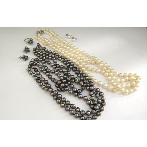 7415 - A double strand dark grey pearl necklace, 76cm long with a matching ring, size S and screw back earr... 