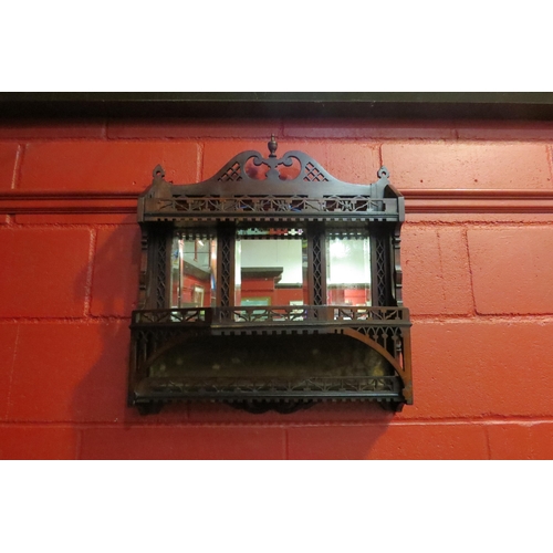 4168 - A Victorian mahogany fret carved three tier wall shelf with triple mirror and finial decoration, 65c... 