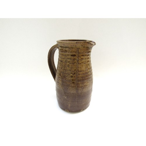 4314 - A studio pottery jug in the Leach tradition, incised detail in mottled brown glaze. Incised mark to ... 