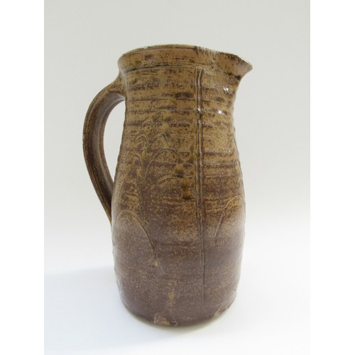 4314 - A studio pottery jug in the Leach tradition, incised detail in mottled brown glaze. Incised mark to ... 