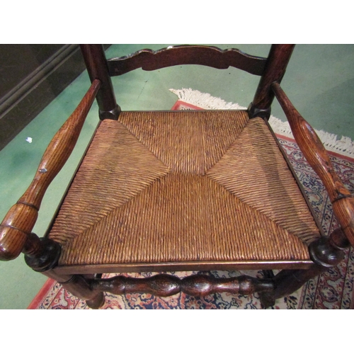 4216 - A Circa 1800 oak six rung ladder back North Country low rush seat armchair on pad foot, turned fore ... 