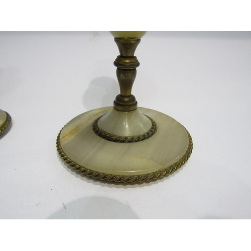 4229 - A pair of brass and onyx candlesticks, 20cm tall