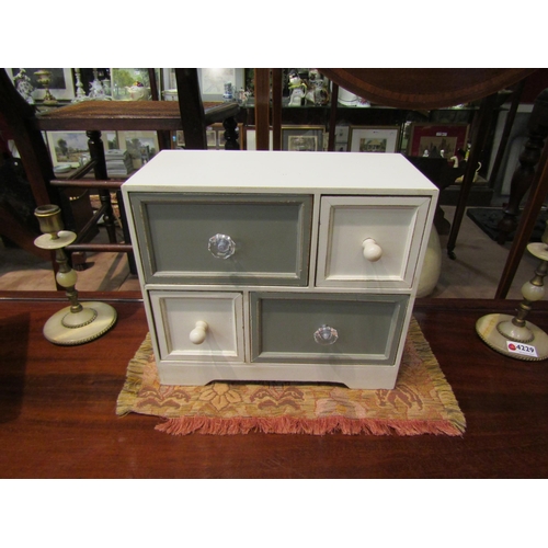 4230 - A painted wooden jewellery chest of four drawers containing miscellaneous items including white meta... 