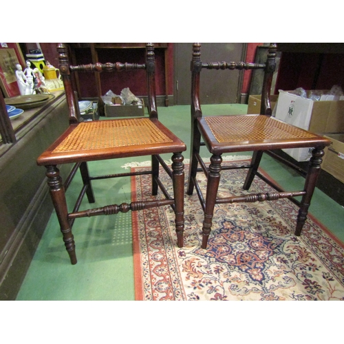 4249 - A pair of early Victorian ash and elm cane seat chairs with turned and fluted central bar back on tu... 