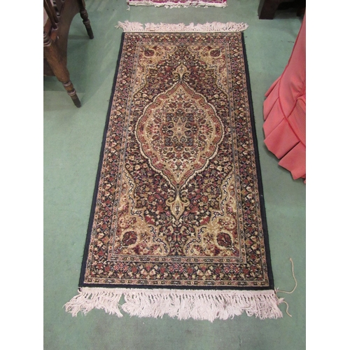 4076 - A small black and gold rug with foliate design and tasselled ends, 135cm x 69cm, together with a red... 