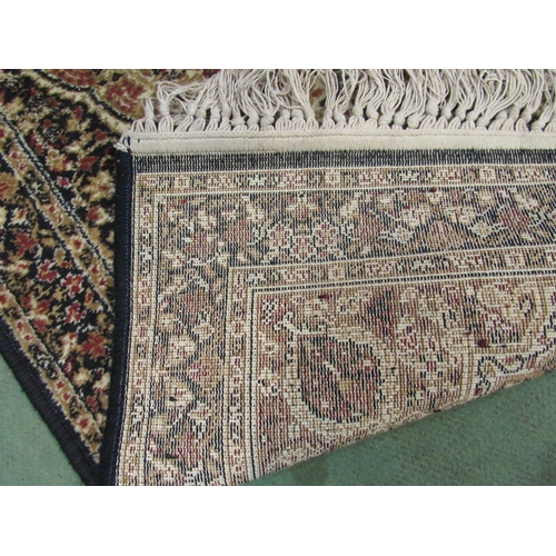 4076 - A small black and gold rug with foliate design and tasselled ends, 135cm x 69cm, together with a red... 