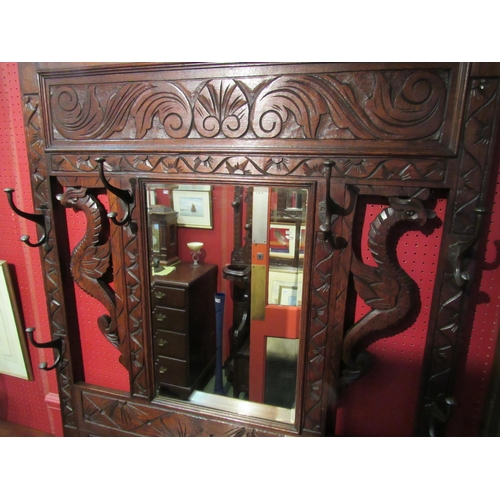 4085 - A late Victorian carved oak hall/stick stand with six coat hooks and carved dragon decoration, the b... 