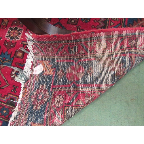 4110 - A Persian Hamadan rug, red ground with geometric and animal design, worn and repaired, 205cm x 134cm... 