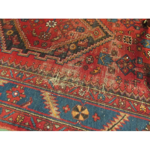 4110 - A Persian Hamadan rug, red ground with geometric and animal design, worn and repaired, 205cm x 134cm... 