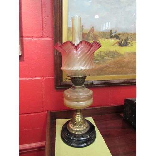 4133 - A brass oil lamp with cut glass reservoir, etched clear and cranberry glass shade