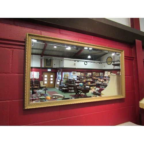 4176 - An ornate gilt framed bevel edged rectangular wall mirror, 70cm x 130cm total