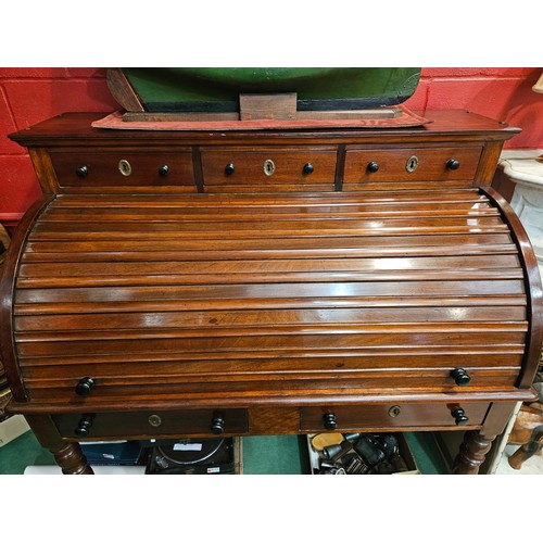 4172 - An early Victorian mahogany roll top desk, the three raised drawers over a tambour front (locking ke... 