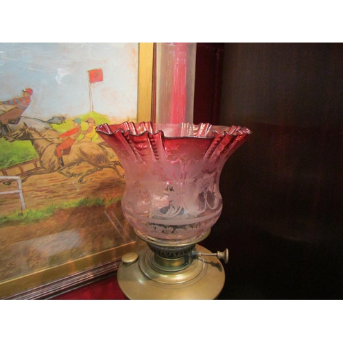 4135 - An oil lamp with cranberry frilled shade