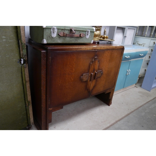 2445 - An Art Deco oak cupboard, two doors opening to reveal a shelved interior